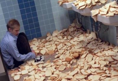 man in a room with hundreds of slices of bread, crouched in corner, clearly intimidated by the superiority of the chad bread